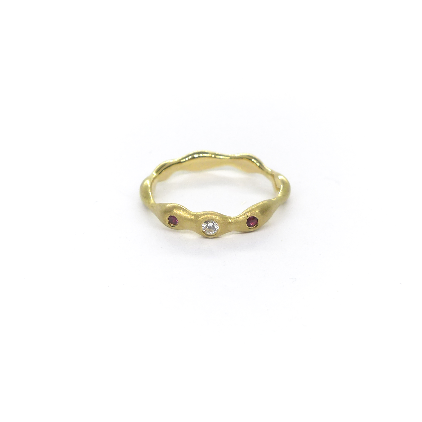 organically-shaped yellowgold ring with a central diamond and two rubies next to it